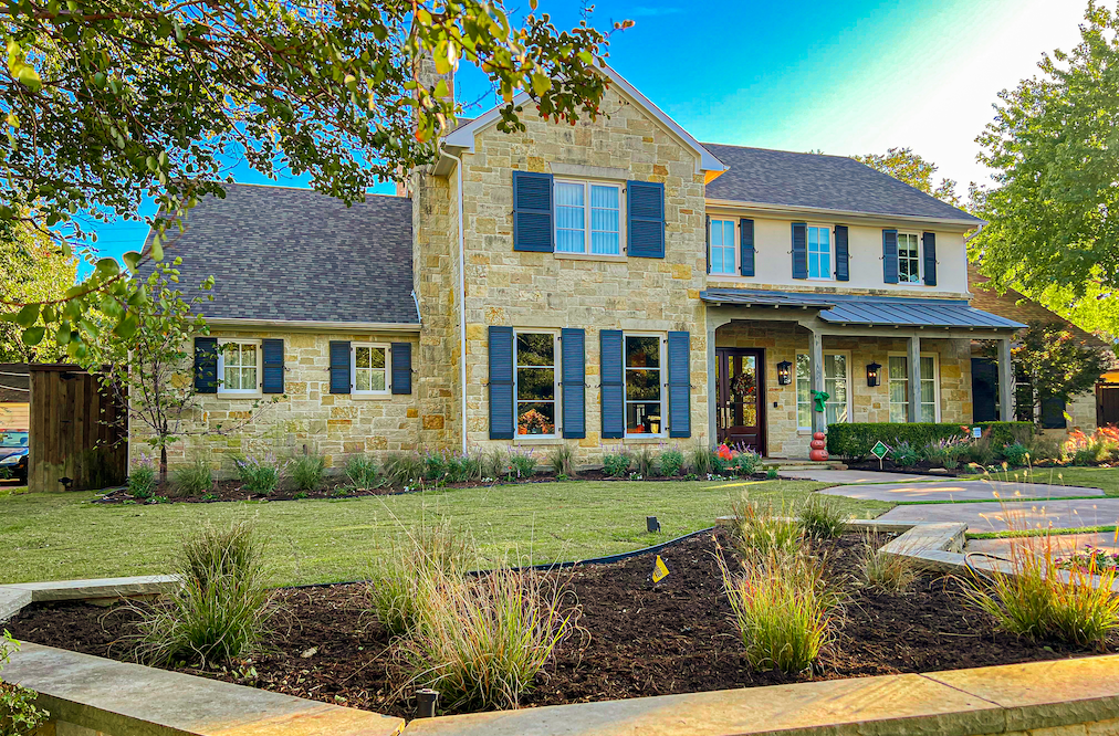 Side view of completed Preston Hollow landscape renovation with layered plantings and lawn