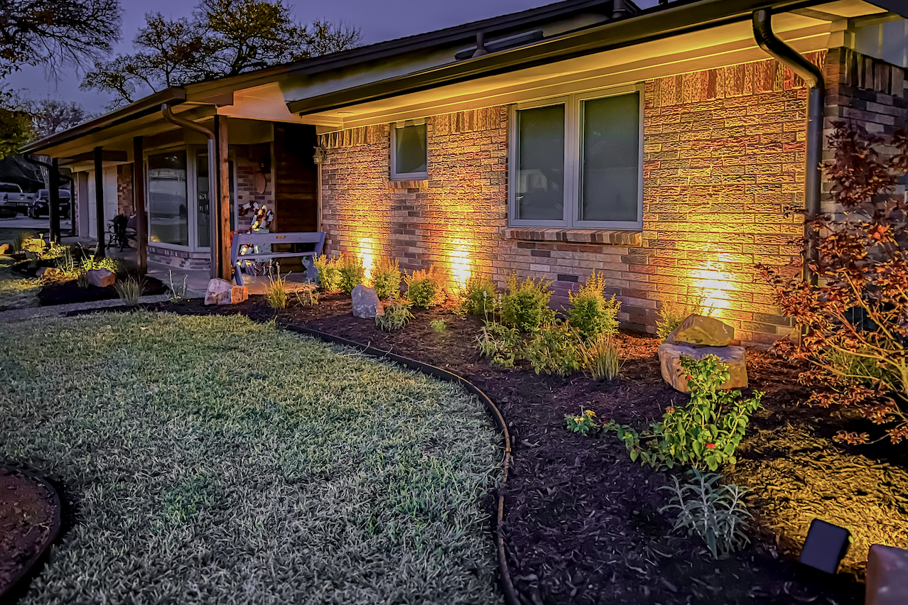 completed Irving landscape overhaul with landscape lighting and perennial garden beds at night