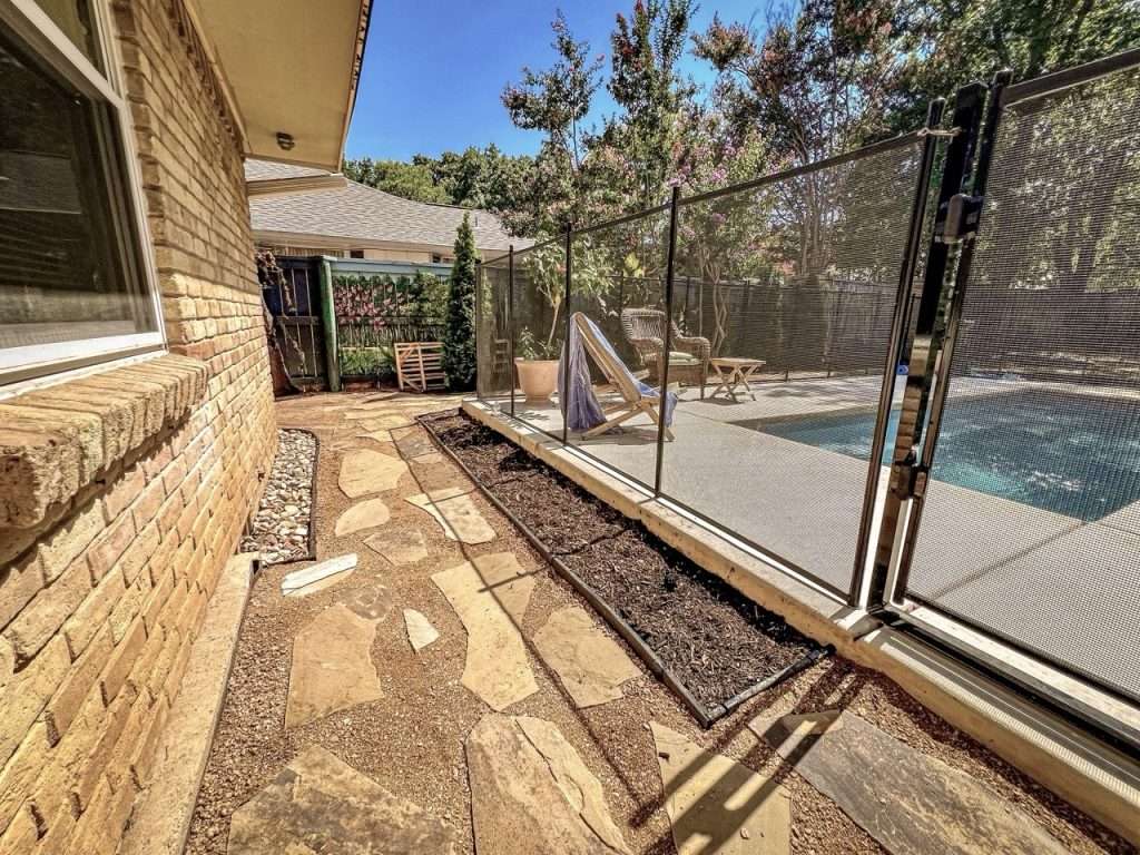 Completed natural flagstone walkway beside residential pool in Dallas