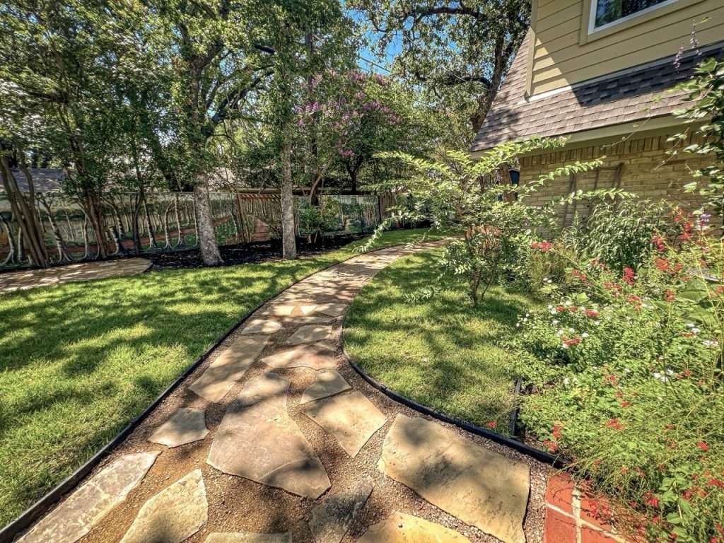 Curved flagstone path through completed Dallas backyard landscape