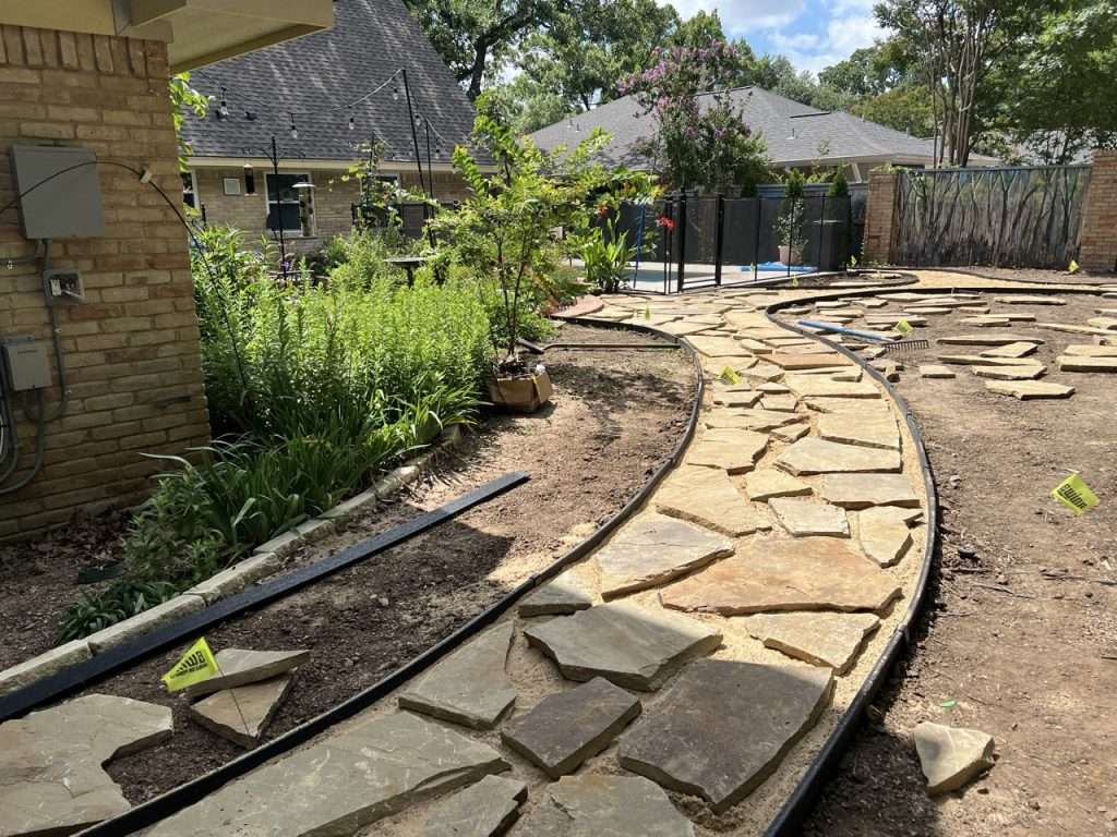 Natural flagstone arranged for custom Dallas backyard walkway installation